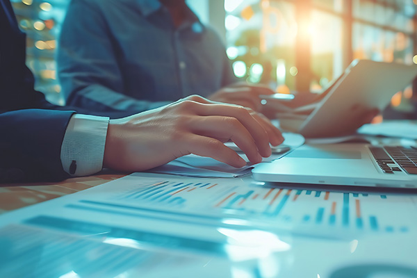 Two business advisors collaborating on financial analysis using digital tablets and printed reports