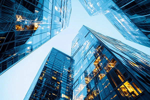 Upward perspective of contemporary office buildings representing transaction advisory services for private equity.